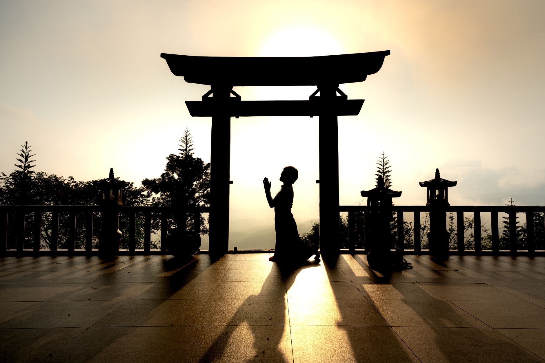 A person praying at sunrise, a moment of spiritual renewal