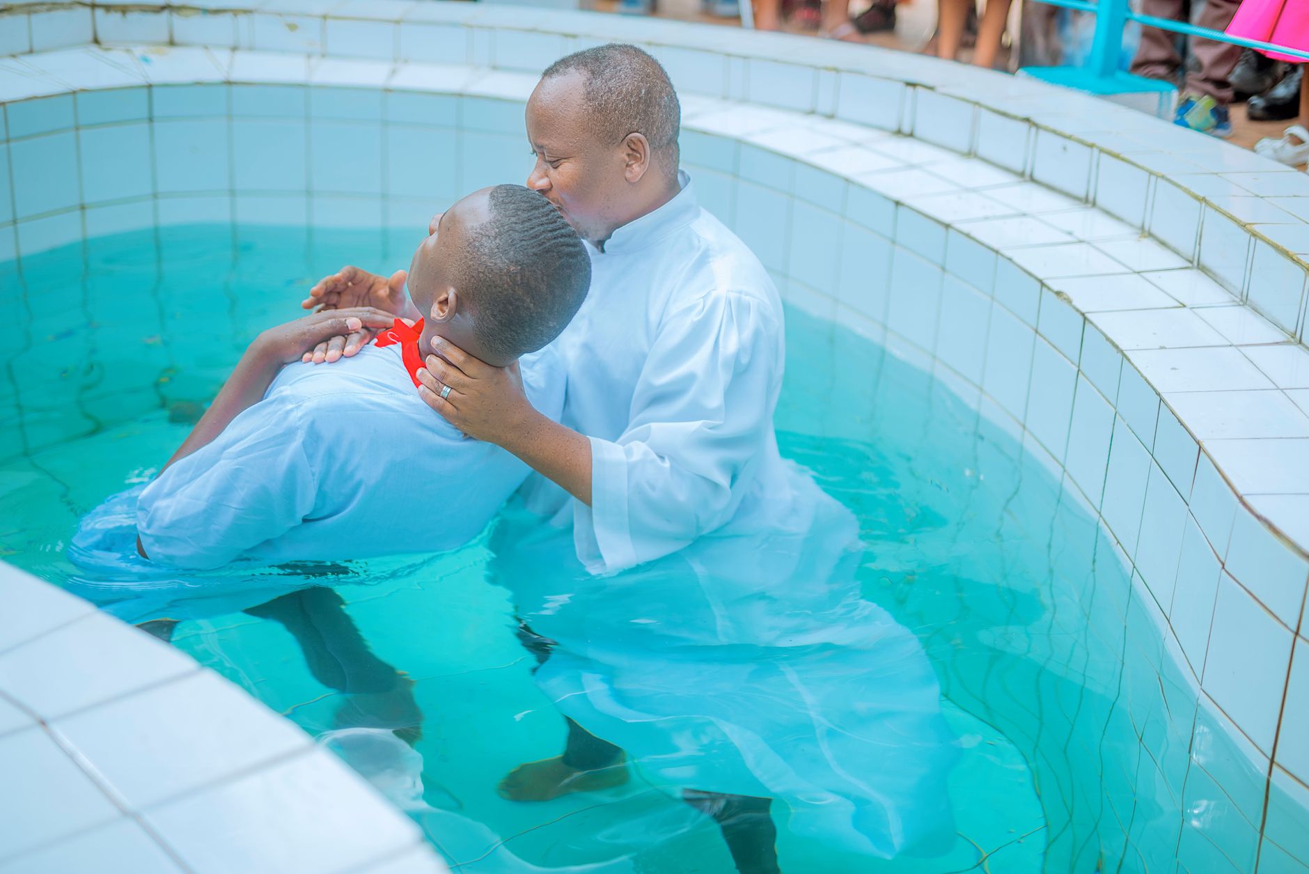 A person being baptized by full water immersion in a river