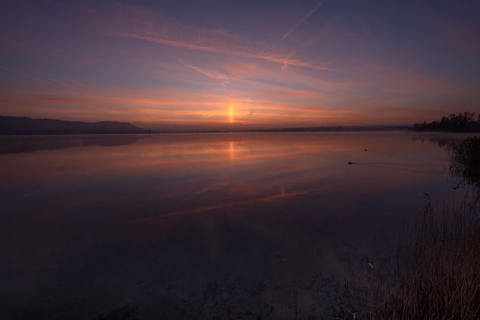 Peaceful sunrise over a tranquil lake — the settled quiet that comes after you stop carrying what God asked you to throw