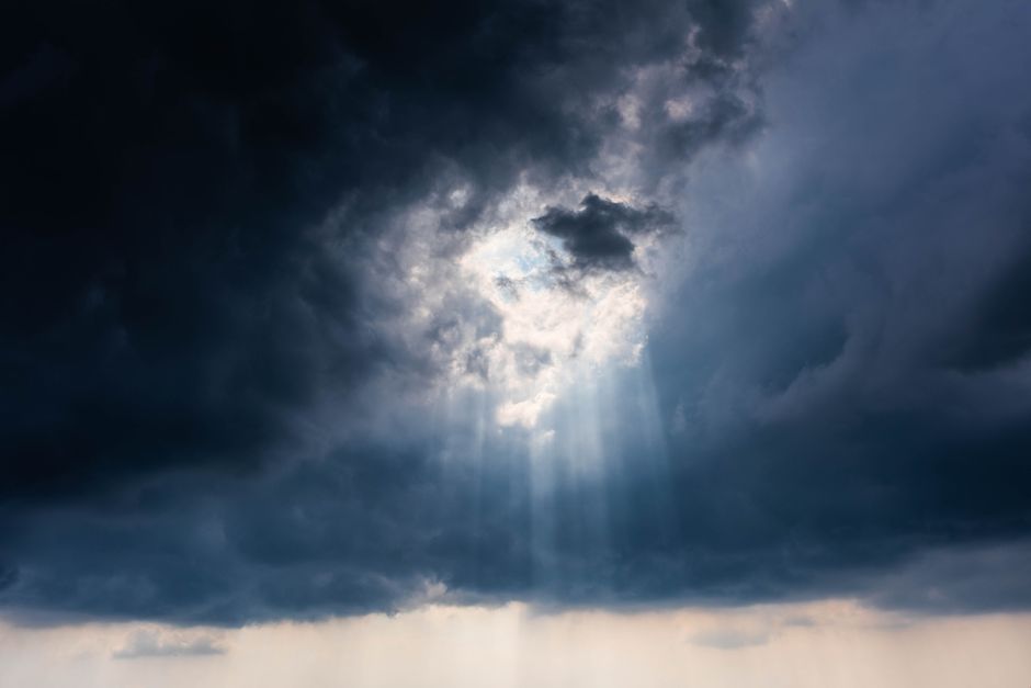 Sunlight breaking through dark storm clouds — God's faithfulness visible on the other side of the hardest season