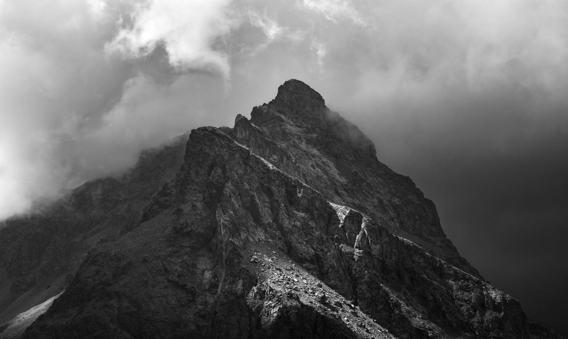 Storm clouds breaking apart over mountains as golden light pours through